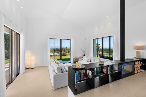 Open-plan living area with abundant natural light and views of the greenery extending to the sea