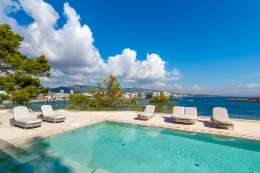 Sunny pool area with sun loungers