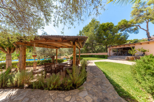 Garden with a covered terrace and pool views