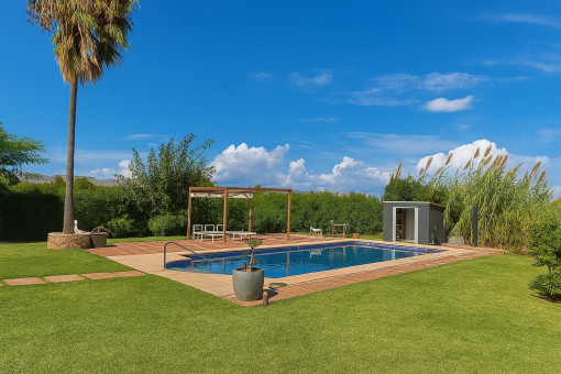 The pool is surrounded by manicured lawns