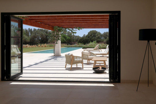 Expansive floor-to-ceiling windows overlooking the pool and garden