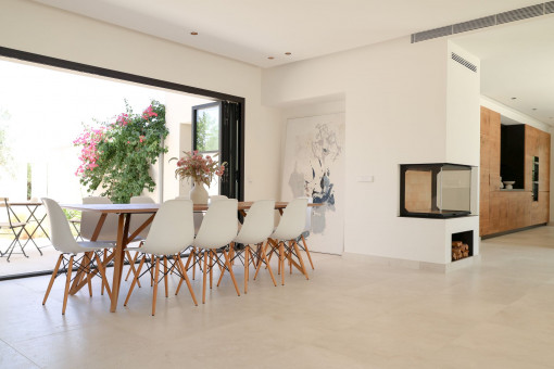 Open-plan living and dining area with a three-sided fireplace