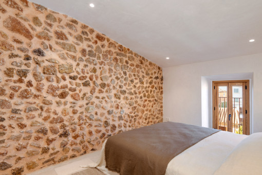 Guest bedroom with stone wall and warm lighting