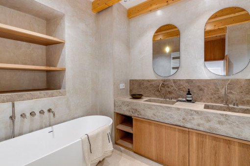 High-end en-suite bathroom with natural stone and freestanding bathtub – timeless design and comfort