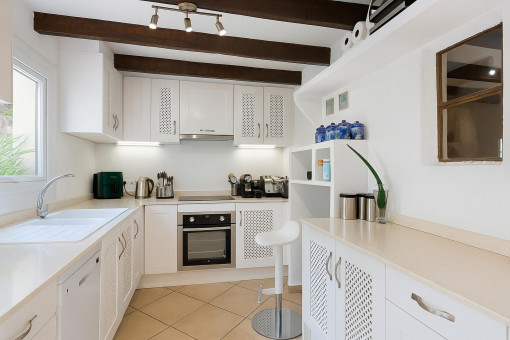 White modern kitchen with traditional beams