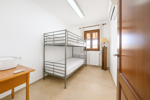 Practical children's room with bunk bed and green views – ideal for families.