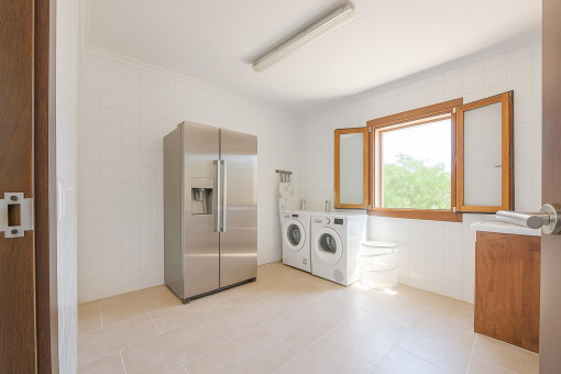Utility room with washing machine, dryer and large fridge-freezer – spacious and bright.