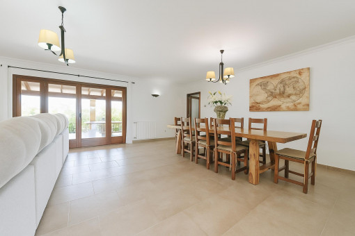 Spacious dining area with large wooden table and access to the covered terrace.