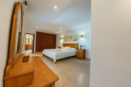 Master bedroom with vanity mirror and direct access to the bathroom