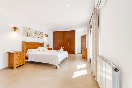 Bright master bedroom with large built-in wardrobe and air conditioning