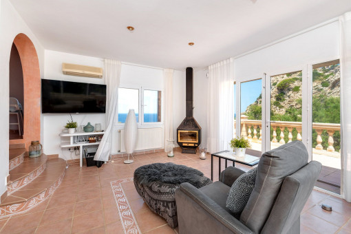 Bright living room with fireplace and access to the sunny terrace with far-reaching views