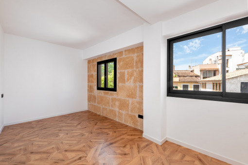 One of the two bedrooms with large windows