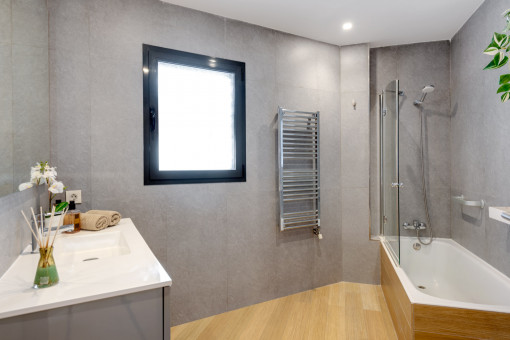 Bathroom with shower tub and towel warmer