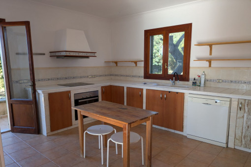 Generous kitchen with wooden fronts, electrical appliances and access to the garden