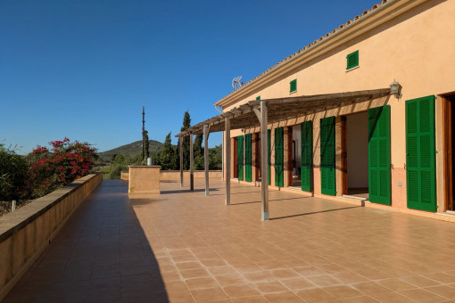 Sunny terrace of the finca with green shutters and pergola, perfect for relaxing outdoors