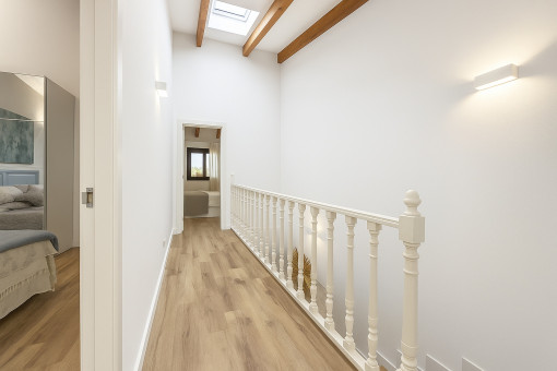 Staircase with skylight and bright gallery hallway to the bedrooms