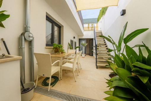 Ground-floor patio with dining area and stairs leading to the pool