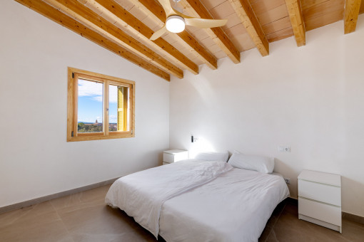 Bedroom with ceiling fan and wooden beams