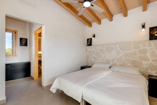 Bedroom with natural stone elements, ceiling fan and en-suite bathroom