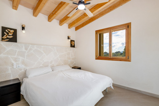 Bedroom with natural stone wall and ceiling fan