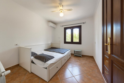 Simple bedroom with window and fan