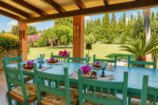 Covered terrace with dining table and garden view