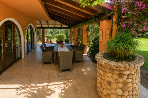 Covered terrace with dining area and garden view