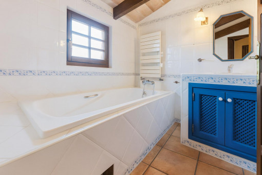 Bathroom with bathtub and blue cabinet