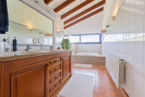 Bright bathroom with bathtub and wood cabinet