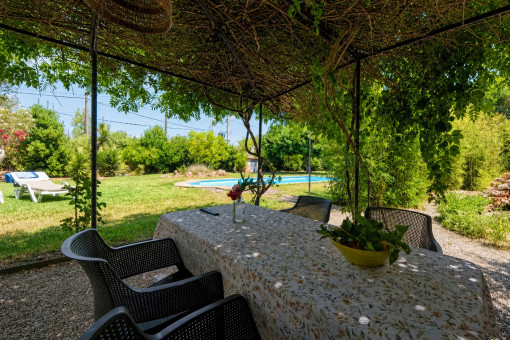 Covered dining area overlooking the pool and garden