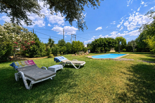 Swimming pool with sun loungers in the landscaped garden