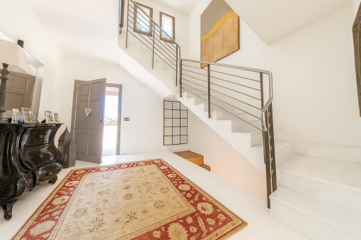 Bright hallway with staircase and rug