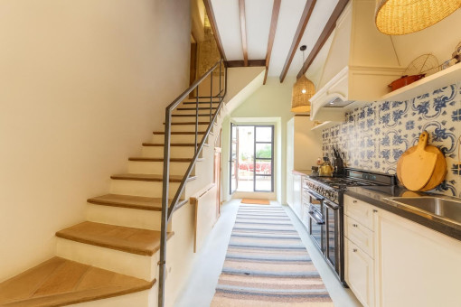 Narrow kitchen with staircase and tile backsplash