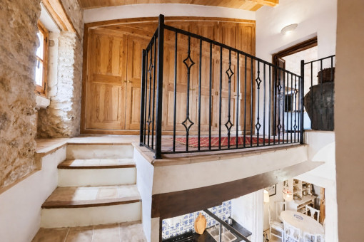 Stone staircase with wooden cupboards and railing