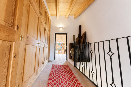 Hallway with wooden cabinets and railing