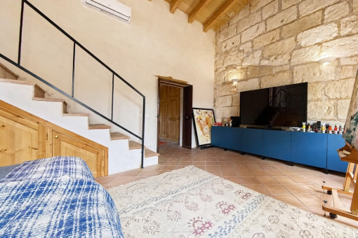 Master bedroom with exposed stone wall