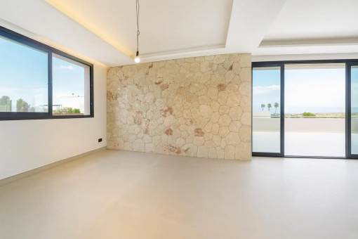 Open-plan living and dining area with natural stone wall
